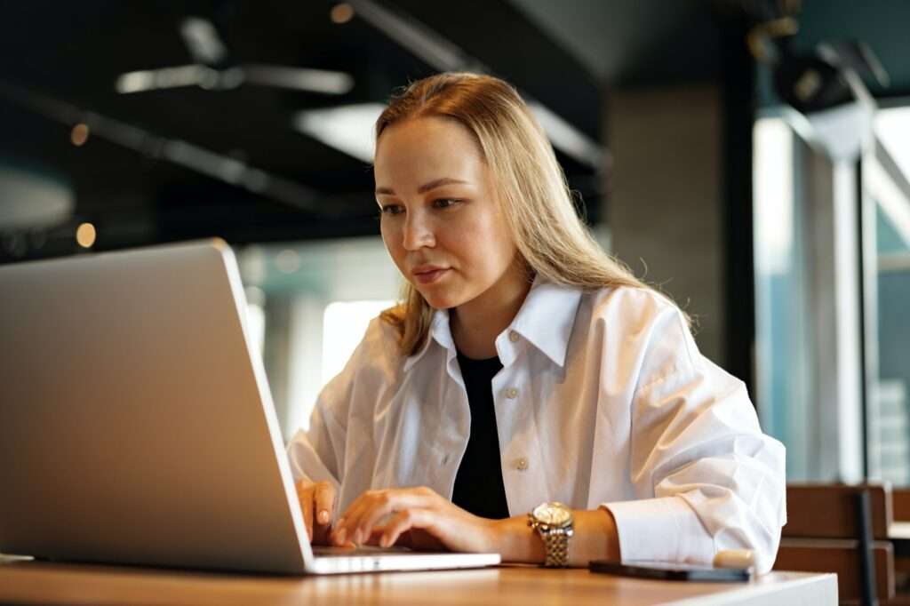 Young businesswoman sitting in a cafe and working with laptop